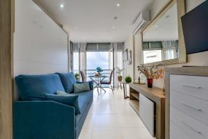 a living room with a blue couch and a table at Estudio Loft Horizonte Playa Fossa Calpe in Calpe