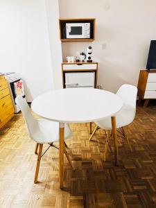 a white table and chairs in a kitchen with a microwave at Hermoso Apartamento en Edificio Saint Michel in Córdoba