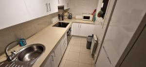 a kitchen with white cabinets and a sink and a sink at Casa Colina Roda Golf in San Javier +20 photos