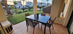 a black table and chairs on a patio with palm trees at Casa Colina Roda Golf in San Javier