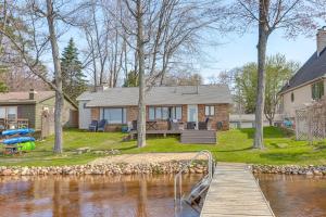凯迪拉克Dock and Views Lake Mitchell Home in Cadillac!的水体旁的房屋