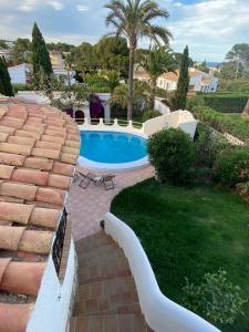 einen Pool in einem Garten mit einem Backsteinsteg in der Unterkunft Ca La Mina in Jávea