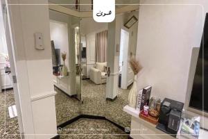 a room with a mirror and a living room at Howa-Flat in Muscat