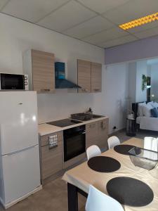 a kitchen with a white refrigerator and a table with chairs at Studios COSY Dour ENGYH house 3 in Dour +11 photos