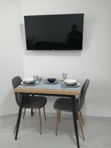 a table with chairs and a television on a wall at Vintage in Shëngjin