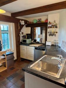 a kitchen with a stainless steel sink in it at Reetdachtraum in Wischhafen in Wischhafen +30 photos