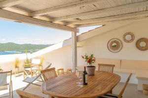 una mesa de madera en un patio con vistas al océano en Suite Sul Golfo - Terrazzo Privato Vista Mare, en Porto Rotondo