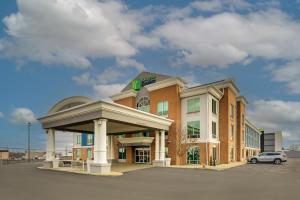 a building with a car parked in a parking lot at Holiday Inn Express Hotel & Suites Richmond by IHG in Richmond