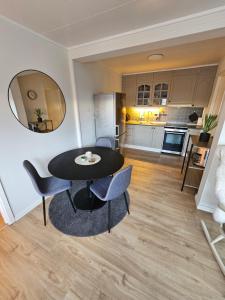 a living room with a table and chairs and a kitchen at Comfy and cozy apartment in Tromsø