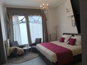 a bedroom with a large bed and a chandelier at Studios COSY Dour ENGYH house 3 in Dour