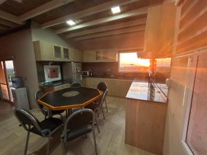 una cocina con mesa y sillas. en Cabañas Balcones de Nogolí - San Luis, en Hipólito Yrigoyen