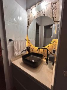 Un baño con un lavabo negro y un espejo. en Cabañas Balcones de Nogolí - San Luis, en Hipólito Yrigoyen 14 fotos más