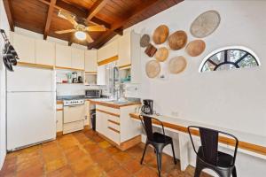 una cocina con electrodomésticos blancos, mesa y sillas en Quiet Secluded Townhouse Just Steps To The Beach!, en Cabo Cañaveral
