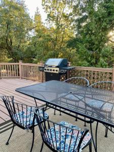 una mesa de picnic con una parrilla en la cubierta en Bearfoot Cabin 15 Min to Yosemite Gate!, en Oakhurst