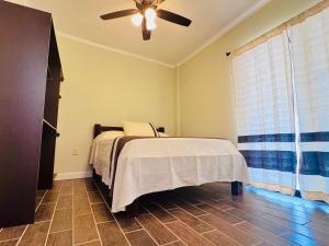 ein Schlafzimmer mit Bett und Deckenventilator in der Unterkunft Casa Brevard in Malucano