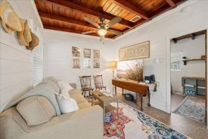 Una sala de estar con un sofá y un piano. en Cozy Beach-side Bungalow!, en Cabo Cañaveral