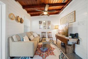 Una sala de estar con un sofá y un piano. en Cozy Beach-side Bungalow!, en Cabo Cañaveral