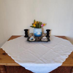 a table with a vase of flowers and candles on it at Leilighet nær E4 i sentrum av Eina in Eina