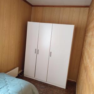 a bedroom with white cabinets and a bed at Leilighet nær E4 i sentrum av Eina in Eina