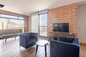 a living room with a brick wall at Departamentos exclusivos, equipados y amueblados en Torre Barrio Vergel in Monterrey