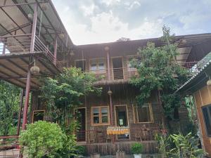 a wooden house with trees in front of it at Moc's House bắc hà in Bắc Hà
