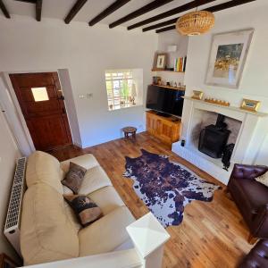 ein Wohnzimmer mit Couch und Kamin in der Unterkunft Gorgeous Two Bedroom Cottage, Pet Friendly! in Snainton