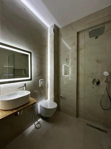a bathroom with a toilet and a sink and a shower at Suzi's apartment in Dhërmi