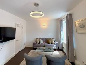 a living room with a couch and two chairs at The Seraphina Suite - Chelsea in London