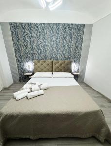 Un dormitorio con una cama grande con toallas. en Shama APARTMENTS, en Palermo