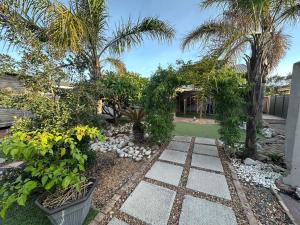 a garden with palm trees and a stone walkway at Suite Dreams Garden Dream Cottage in Panorama