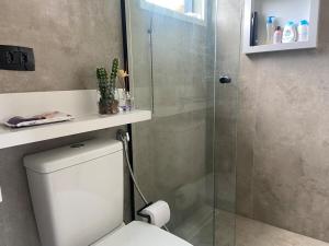 a bathroom with a toilet and a glass shower at Container-house - Serra da Mantiqueira - MG in Toledo +41 photos