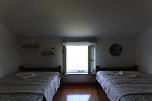two beds in a room with a window at Solar Hill Home in Žrnovo