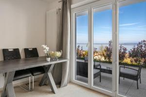 a dining room with a table and a view of the ocean at Littoral Lac in Gorgier