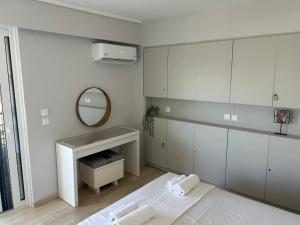 a white bathroom with a sink and a mirror at Athens Riviera, Modern Vouliagmeni Flat at Cape of Lemos in Athens