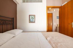 a bedroom with a large bed with a wooden headboard at "La Vie Est Belle" by the sea Rethymno in Rethymno