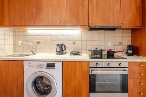 a kitchen with a washing machine and a sink at "La Vie Est Belle" by the sea Rethymno in Rethymno