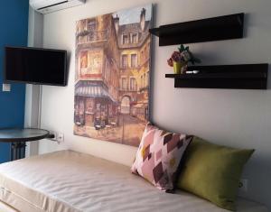 a bedroom with a bed with a painting on the wall at "La Vie Est Belle" by the sea Rethymno in Rethymno