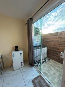 a bathroom with a sliding glass door and a refrigerator at hospedagem alexandres in Cabo Frio