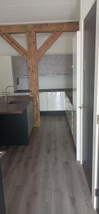 a kitchen with wooden beams in a room with wooden floors at Golf course around the corner! in Nieuwveen +4 photos