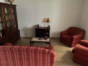a living room with a couch and a chair and a table at Casa na praia- Maia in Maia