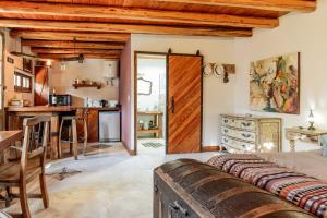 a living room with a wooden door and a kitchen at Aromos de Olivares in Chacras de Coria
