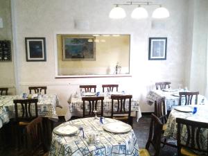 comedor con mesas, sillas y espejo en Hotel Aurora, en Loano