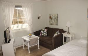 mały salon z kanapą i łóżkiem w obiekcie Sandli Overnatting w mieście Alvdal
