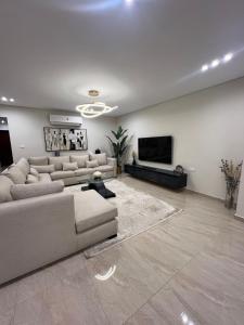 a living room with couches and a flat screen tv at Charming Apartment - Near Cairo Airport in Cairo