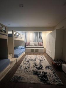 a bedroom with two bunk beds and a rug at Charming Apartment - Near Cairo Airport in Cairo