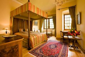 Hotel Burg Arras في الف: غرفة نوم بها سرير مظلة وسجادة