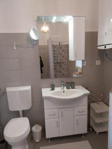a bathroom with a sink and a toilet and a mirror at BONI apartman in Balatonboglár +21 photos