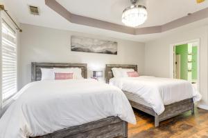 2 camas en un dormitorio con paredes blancas y suelo de madera en 18 Mi to Atlanta Family Retreat with Patio, en Rex