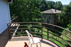 a balcony with a white chair and a building at Albergue ARMAÑON in Trucios-Turtzioz