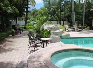 einen Pool mit Stühlen und einem Tisch daneben in der Unterkunft Royal Palms Villa, Pool, Spa, Private Gate, 1,5 acre in Delta